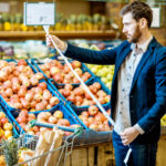 Hombre leyendo la factura en el mercado y viendo el aumento de precios: impacto de la inflación en el ahorro familiar